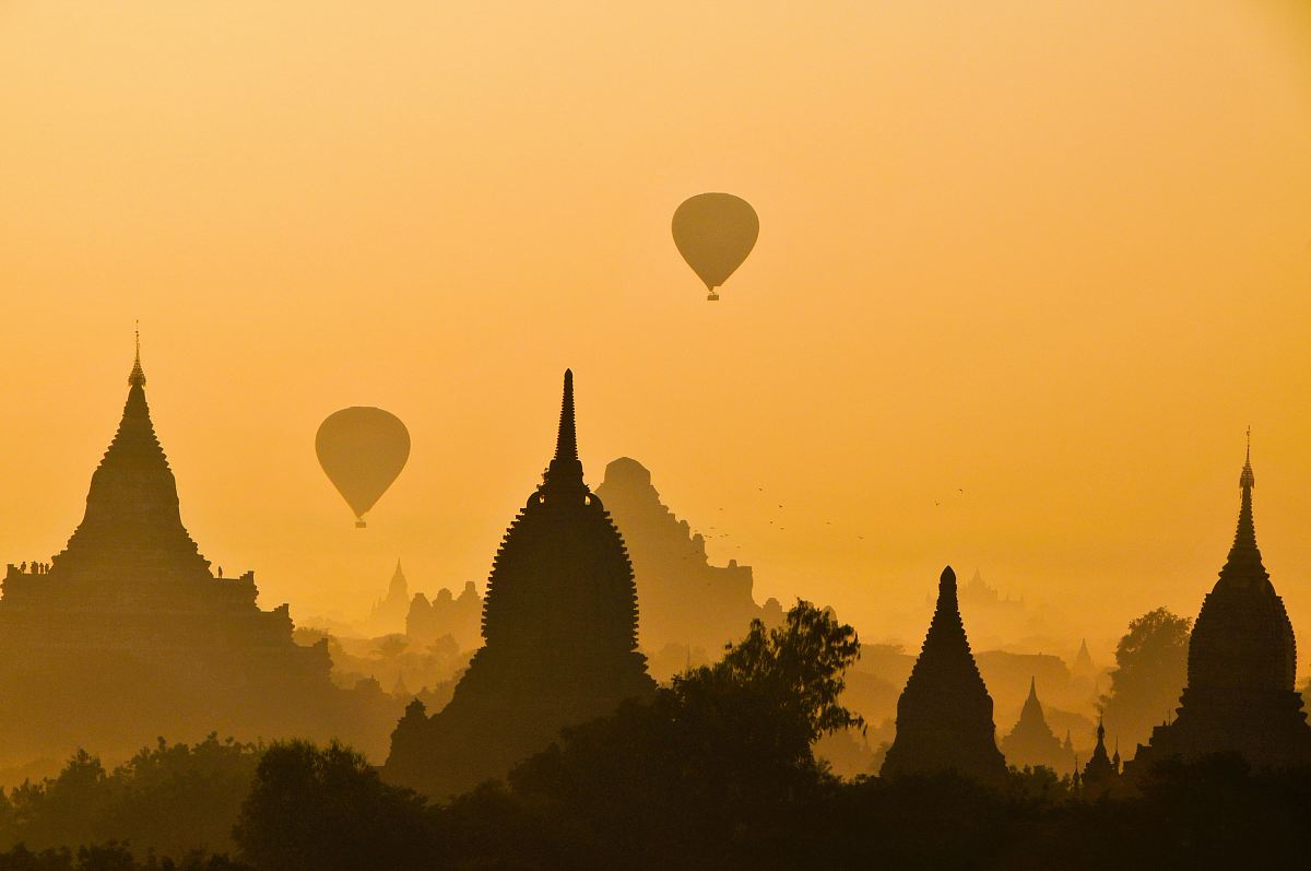silhouette of two hot air balloons near temple